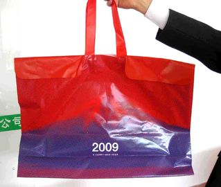 L'abitudine ha stampato i grandi sacchetti della spesa di plastica con le maniglie/bottone della corda